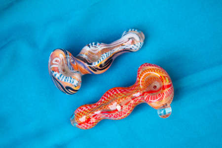 Glass pipe or bong for marijuana smoking on a blue fabric backgroundの写真素材