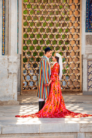 Samarkand, Uzbekistan - April 18, 2021: Bride and groom in traditional uzbek dresses at Registan ancient city, Samarkand city in Uzbekistanのeditorial素材