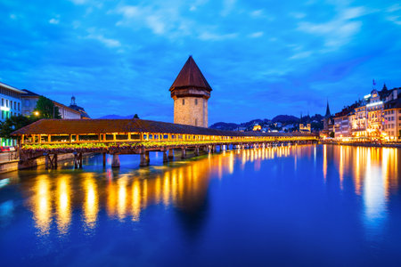 Kapellbrucke or Chapel Bridge is a wooden footbridge spanning Reuss river and Wasserturm water tower in Lucerne city, central Switzerlandの写真素材