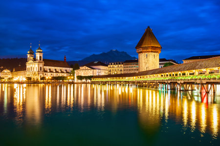 Kapellbrucke or Chapel Bridge is a wooden footbridge spanning Reuss river and Wasserturm water tower in Lucerne city, central Switzerlandの写真素材