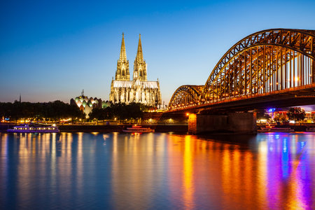 Cologne Cathedral and Hohenzollern Bridge through Rhine river in Cologne, Germanyの写真素材