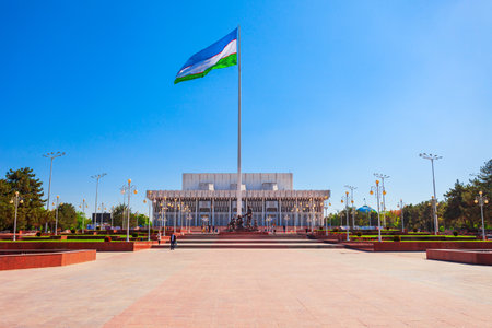 Tashkent, Uzbekistan - April 11, 2021: National Flag and Friendship of Peoples Palace at the Bunyodkor square in Tashkent city, Uzbekistanのeditorial素材