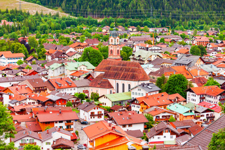 The Roman Catholic parish church of St. Peter and Paul aerial panoramic view, Mittenwald in the Upper Bavarian district of Garmisch-Partenkirchen, Germanyの写真素材