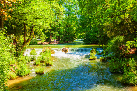 Waterfall at Schwabinger Bach stream in English Garden or Englischer Garten, a large public park in the centre of Munich, Bavariaの写真素材