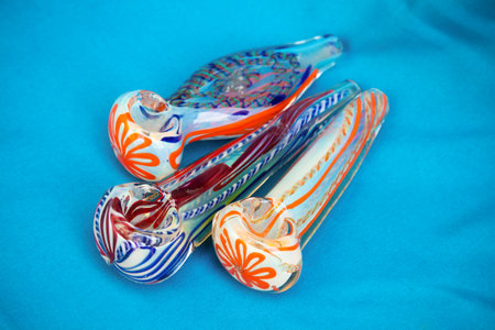 Glass pipe or bong for marijuana smoking on a blue fabric backgroundの写真素材