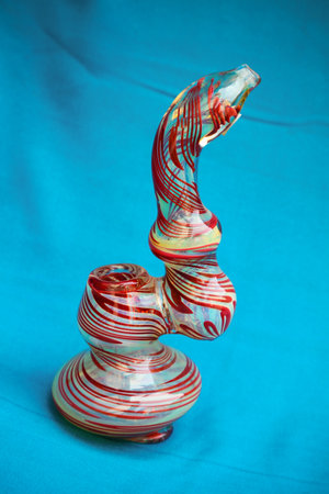 Glass pipe or bong for marijuana smoking on a blue fabric backgroundの写真素材