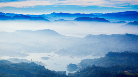 Foggy mountains aerial panoramic view from the Adams Peak or Sri Pada on sunrise. Adams Peak is a tall and holy buddhist mountain in Sri Lanka.の写真素材
