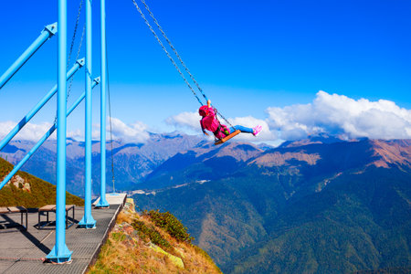 Swings above the clouds attraction at Rose or Rosa Peak mountain station in Sochi resort region in Krasnodar Krai, Russiaの写真素材