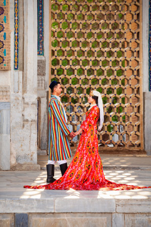 Samarkand, Uzbekistan - April 18, 2021: Bride and groom in traditional uzbek dresses at Registan ancient city, Samarkand city in Uzbekistanのeditorial素材