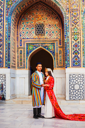Samarkand, Uzbekistan - April 18, 2021: Bride and groom in traditional uzbek dresses at Registan ancient city, Samarkand city in Uzbekistanのeditorial素材