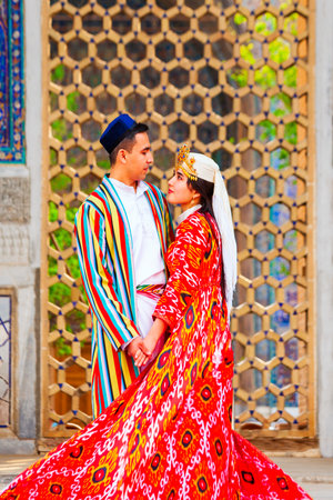 Samarkand, Uzbekistan - April 18, 2021: Bride and groom in traditional uzbek dresses at Registan ancient city, Samarkand city in Uzbekistanのeditorial素材