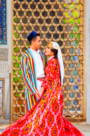 Samarkand, Uzbekistan - April 18, 2021: Bride and groom in traditional uzbek dresses at Registan ancient city, Samarkand city in Uzbekistanのeditorial素材