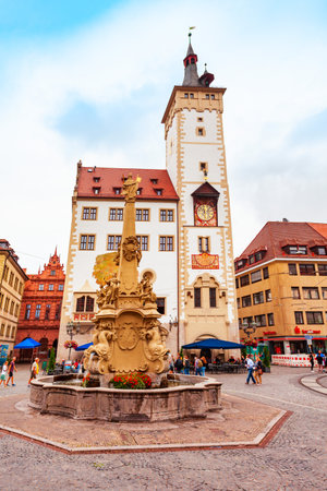 Wurzburg, Germany - July 11, 2021: Vierrohrenbrunnen fountain and Old Town Hall or Rathaus in Wurzburg old town. Wurzburg or Wuerzburg is a city in Franconia region of Bavaria, Germany.のeditorial素材
