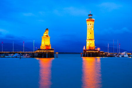 New Lindau Lighthouse and Bavarian Lion Sculpture at the Lindau harbor at night. Lindau is a major town and island on the Lake Constance or Bodensee in Bavaria, Germany.の写真素材