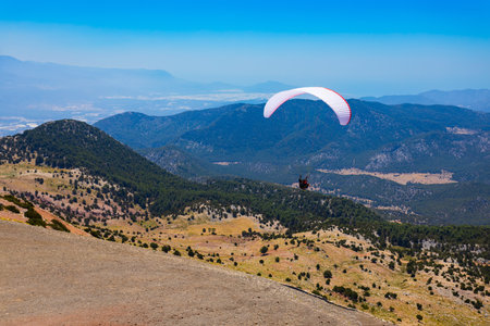 Flying paraglider at the top of Babadag mountain in Turkey. Oludeniz or Blue Lagoon is a beach resort in the Fethiye district of Mugla Province, Turkey.の写真素材