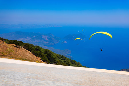 Flying paraglider at the top of Babadag mountain in Turkey. Oludeniz or Blue Lagoon is a beach resort in the Fethiye district of Mugla Province, Turkey.の写真素材