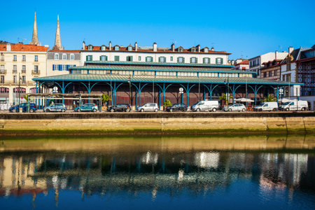 Main public market and colorful houses at the Nive river embankment in Bayonne town in Franceの写真素材