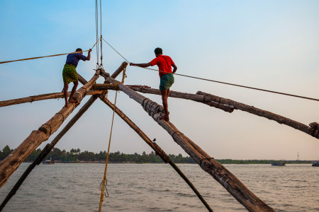 Unidentified fishermen and chinese fishing nets in Fort Kochi in Cochin, Indiaの写真素材
