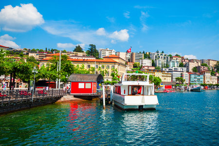 Tourist boat in Lugano lake and Lugano city in canton of Ticino in Switzerlandの写真素材