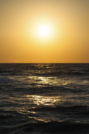 Classic seascape with a view of the setting sun and wavesの写真素材