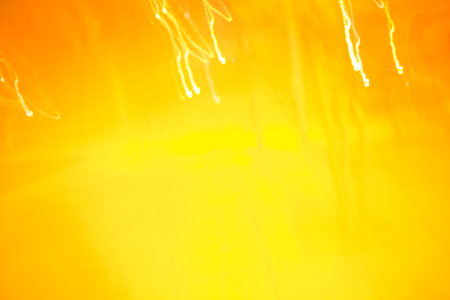 Abstraction. Light beams on yellow and orange background.の写真素材