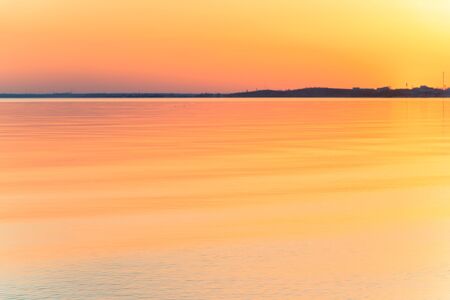 Evening sunset with beautiful sun glare on the waterの写真素材