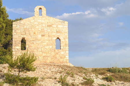 Restored religious church wall in Verudela on a rocky seashoreの写真素材