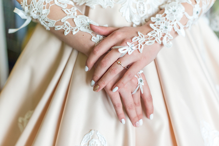Bride's hands in white dressの写真素材