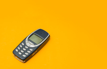 vintage mobile phone with copyspace on yellow background