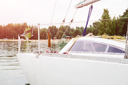 Board of a white sailing yacht on the river