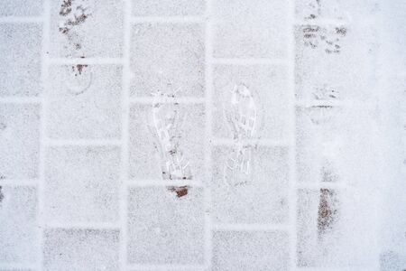 snowy paving slabs with traces of shoes