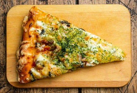 A slice of pizza on a cutting board