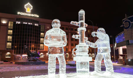Tyumen, Russia - January 8, 2021: Rosneft office. Ice sculpture workers on night background.のeditorial素材