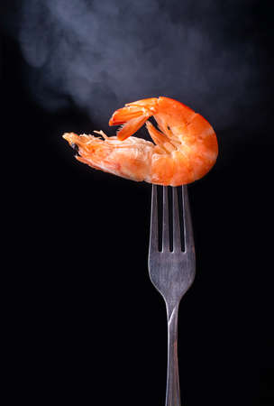 Shrimp on the fork with black backgroundの写真素材