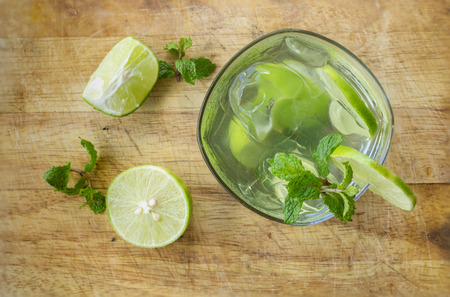 Mojito , lime pieces , leaves of mint with ice and rum top view