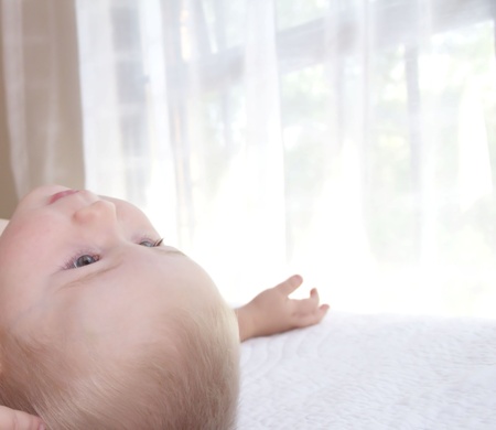 Baby boy is lying and looking upの写真素材