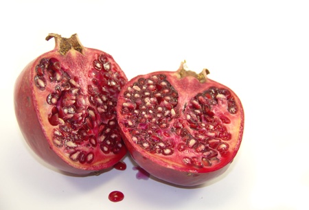 Halves of pomegranate fruit isolated on white backgroundの写真素材