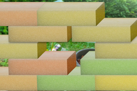 colorful rectangular foam sponges neatly arranged or stacked against a blurry garden background
