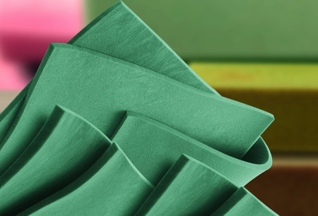 sheets of thin green foam material in a blurry warehouse room. folded material sample sheetの写真素材