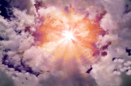 sun rays and white clouds against a dramatic dark sky background. thick wisps of clouds with orange...