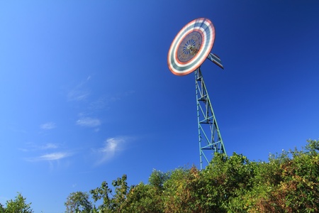 Water pumping windmills for pumping water with spinning blades against a blue sky with clouds.の写真素材