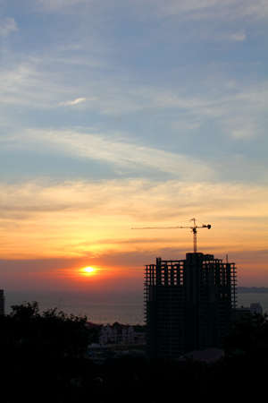 buildings under construction with cranes in nature scene sunsetの写真素材