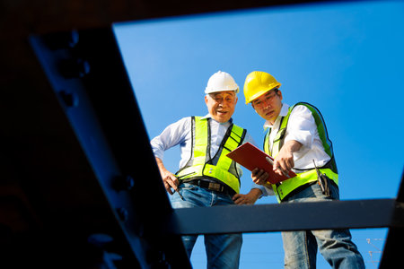 Professional maintenance team checking cargo train condition and railway equipment to ensure...