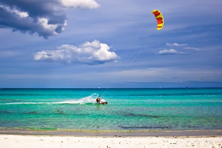 A kitesurfer gliding near the beach La Cinta, Sardiniaの写真素材