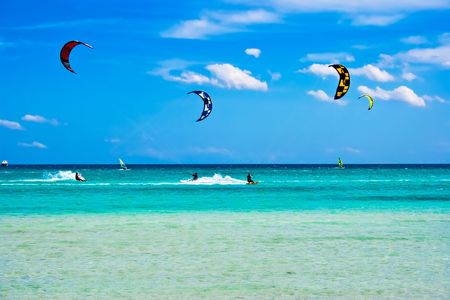 Kitesurfers gliding at high speed around the beach Cinta, Sardiniaの写真素材