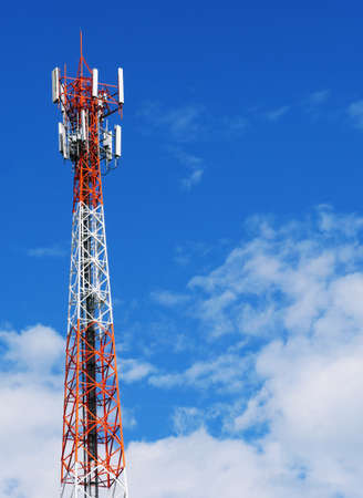 Telephone tower with white clouds in the background.
