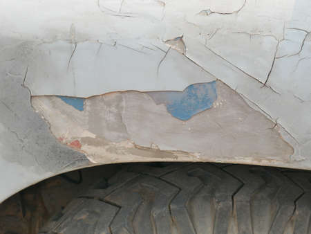 Rust on the side of white old car. Rust hole on old worn painted metal surface.の写真素材