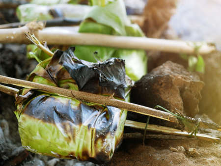 Cooking by wrapping banana leaves and grilling them on fire.の写真素材
