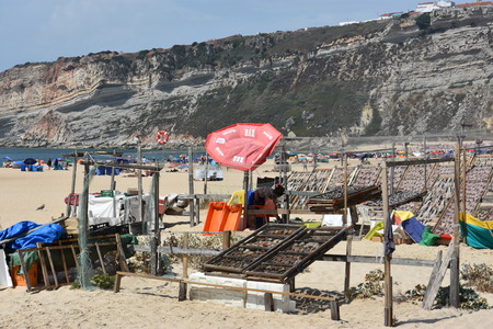 Drying fish on the beach at Nazare fishing village in Portugalの写真素材