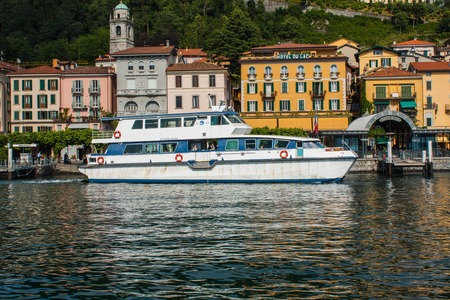 BELLAGIO ON LAKE COMO, ITALY, JUNE 15, 2014. View on coast line of Bellagio city on Lake Como, Italy. Italian landscape city with hotel, buildings on the shore and ferry, water taxi boat.のeditorial素材